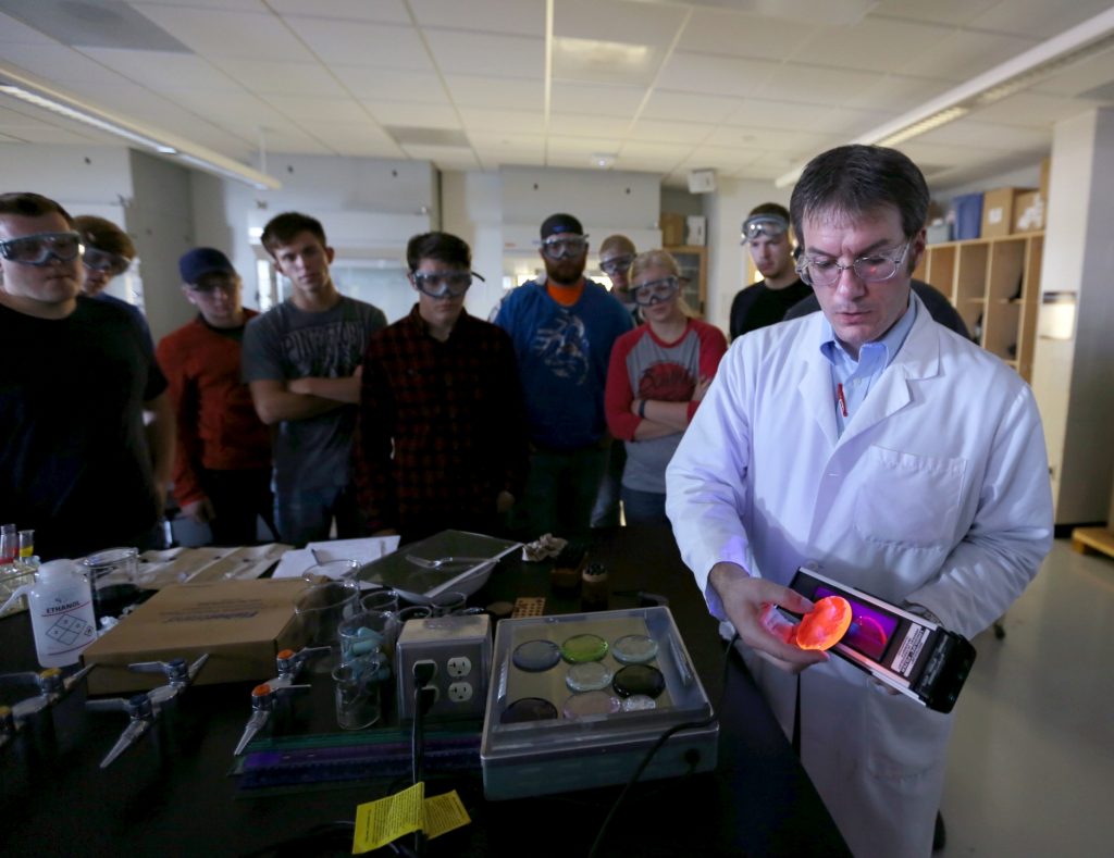 Students work in the lab during Associate Professor Matthew Ray's Chemistry of Materials class An engineering student works on mathematics coursework in Jarvis Hall Thursday, September 28, 2017. Pictured is the class comparing amorphous glass behavior with the crystalline solid behavior observed in the first part of the lab. They prepared batches of soda lime glass and varied the ingredients to change the melt viscosity and color. Glasses of various colors were prepared by adding small amounts of metal oxides to the glass mixture before firing to melt and react all of the ingredients together. The glass mixtures were placed into crucibles and heated overnight to 1150°C (2100°F), then poured onto an iron slab and allowed to cool. To observe fluorescence, the europium and terbium doped samples were illuminated with an ultraviolet lamp (365 nm light) which revealed the bright red and green fluorescence. (UW-Stout Photo by Brett T. Roseman)