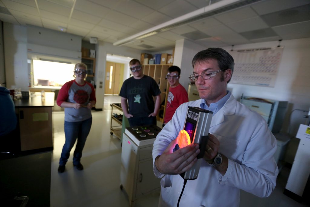 Students work in the lab during Associate Professor Matthew Ray's Chemistry of Materials class An engineering student works on mathematics coursework in Jarvis Hall Thursday, September 28, 2017. Pictured is the class comparing amorphous glass behavior with the crystalline solid behavior observed in the first part of the lab. They prepared batches of soda lime glass and varied the ingredients to change the melt viscosity and color. Glasses of various colors were prepared by adding small amounts of metal oxides to the glass mixture before firing to melt and react all of the ingredients together. The glass mixtures were placed into crucibles and heated overnight to 1150°C (2100°F), then poured onto an iron slab and allowed to cool. To observe fluorescence, the europium and terbium doped samples were illuminated with an ultraviolet lamp (365 nm light) which revealed the bright red and green fluorescence. (UW-Stout Photo by Brett T. Roseman)