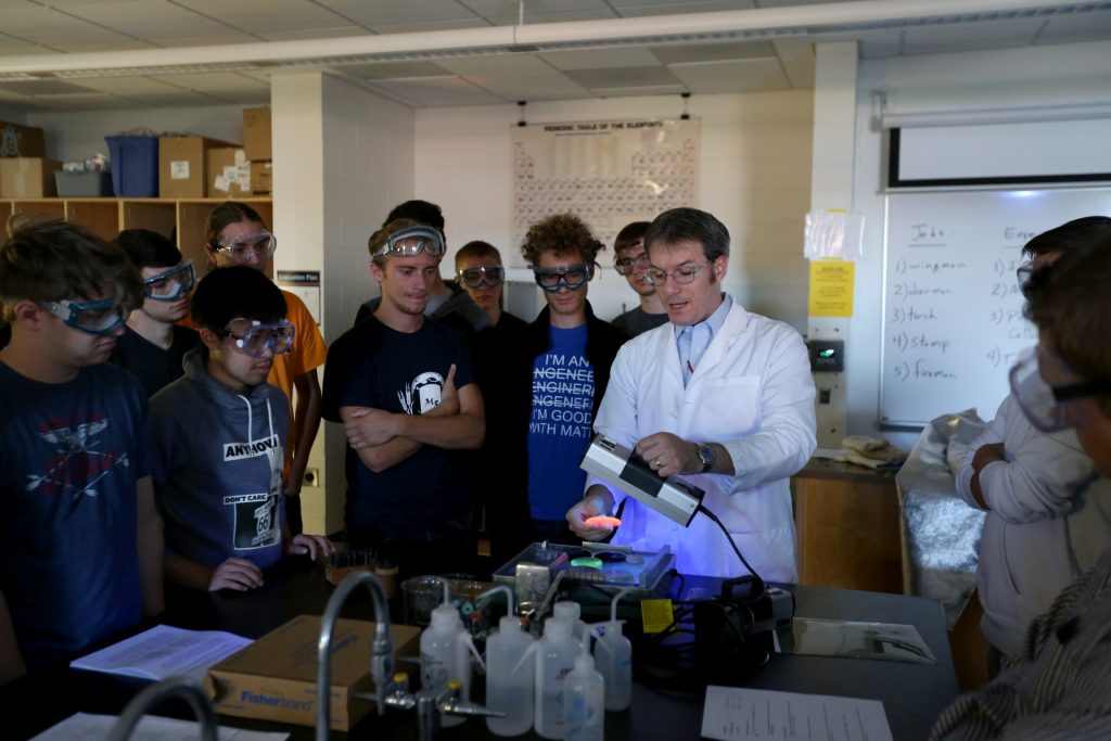 Students work in the lab during Associate Professor Matthew Ray's Chemistry of Materials class An engineering student works on mathematics coursework in Jarvis Hall Thursday, September 28, 2017. Pictured is the class comparing amorphous glass behavior with the crystalline solid behavior observed in the first part of the lab. They prepared batches of soda lime glass and varied the ingredients to change the melt viscosity and color. Glasses of various colors were prepared by adding small amounts of metal oxides to the glass mixture before firing to melt and react all of the ingredients together. The glass mixtures were placed into crucibles and heated overnight to 1150°C (2100°F), then poured onto an iron slab and allowed to cool. To observe fluorescence, the europium and terbium doped samples were illuminated with an ultraviolet lamp (365 nm light) which revealed the bright red and green fluorescence. (UW-Stout Photo by Brett T. Roseman)